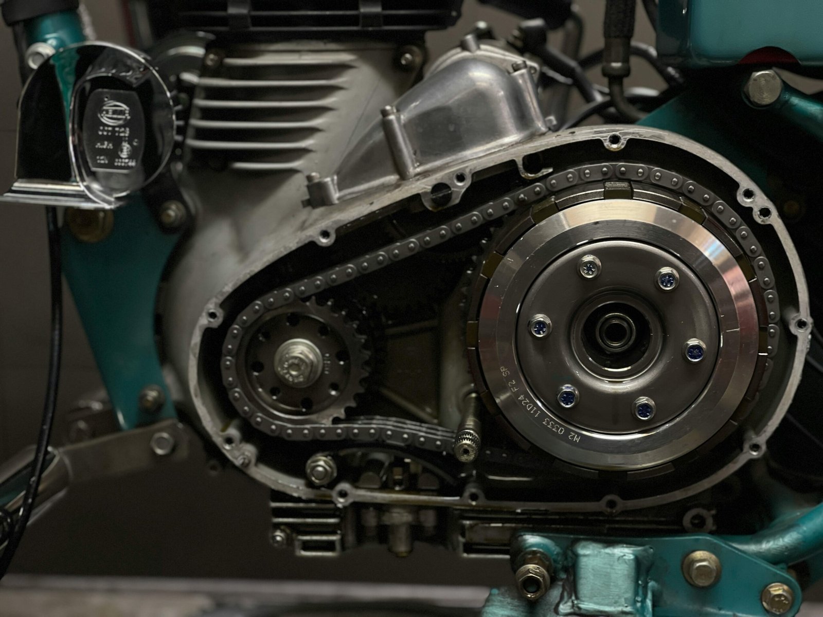 Detailed view of a motorcycle engine's components and chain system.